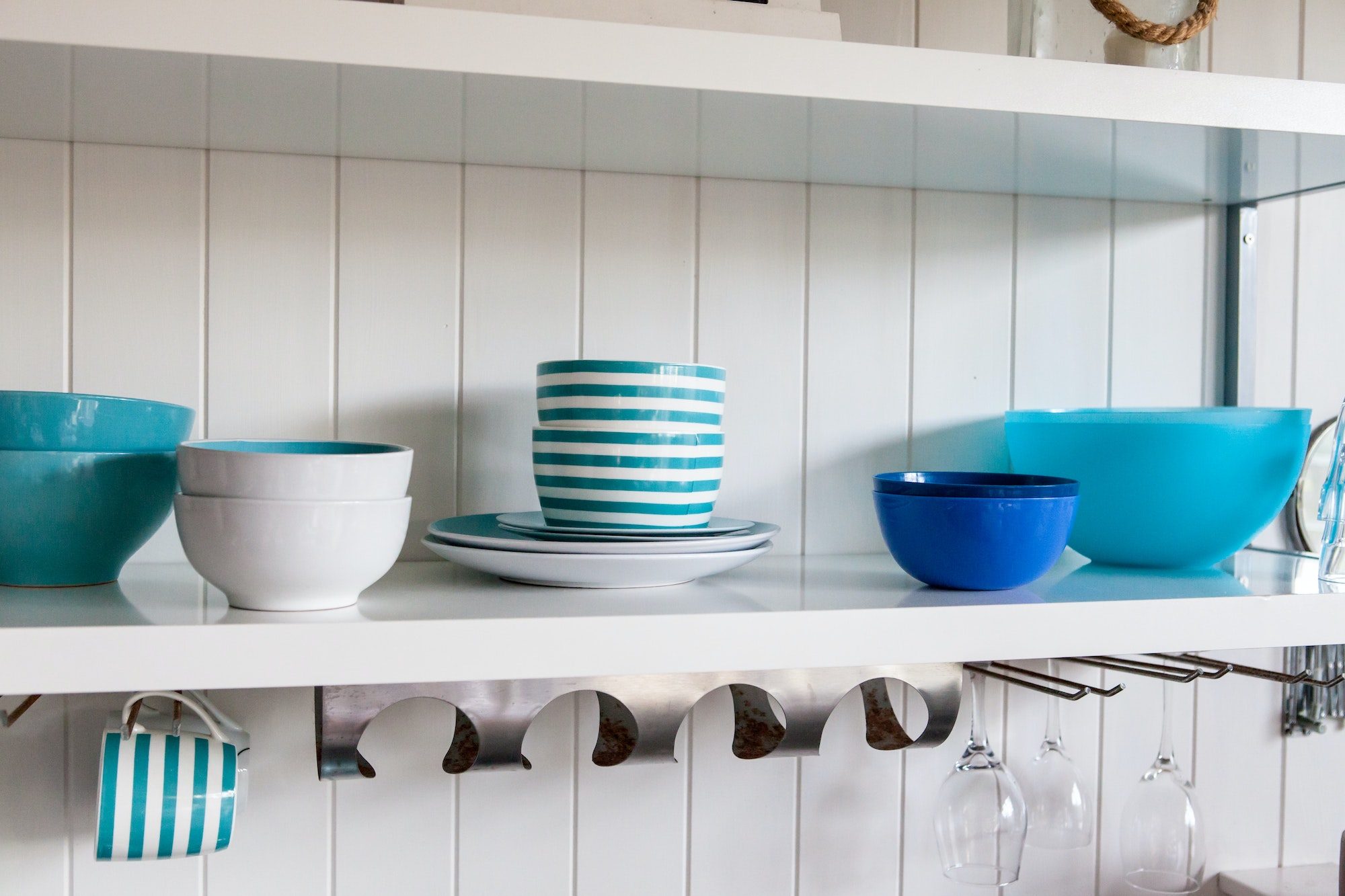 blue and white dishes on white shelf