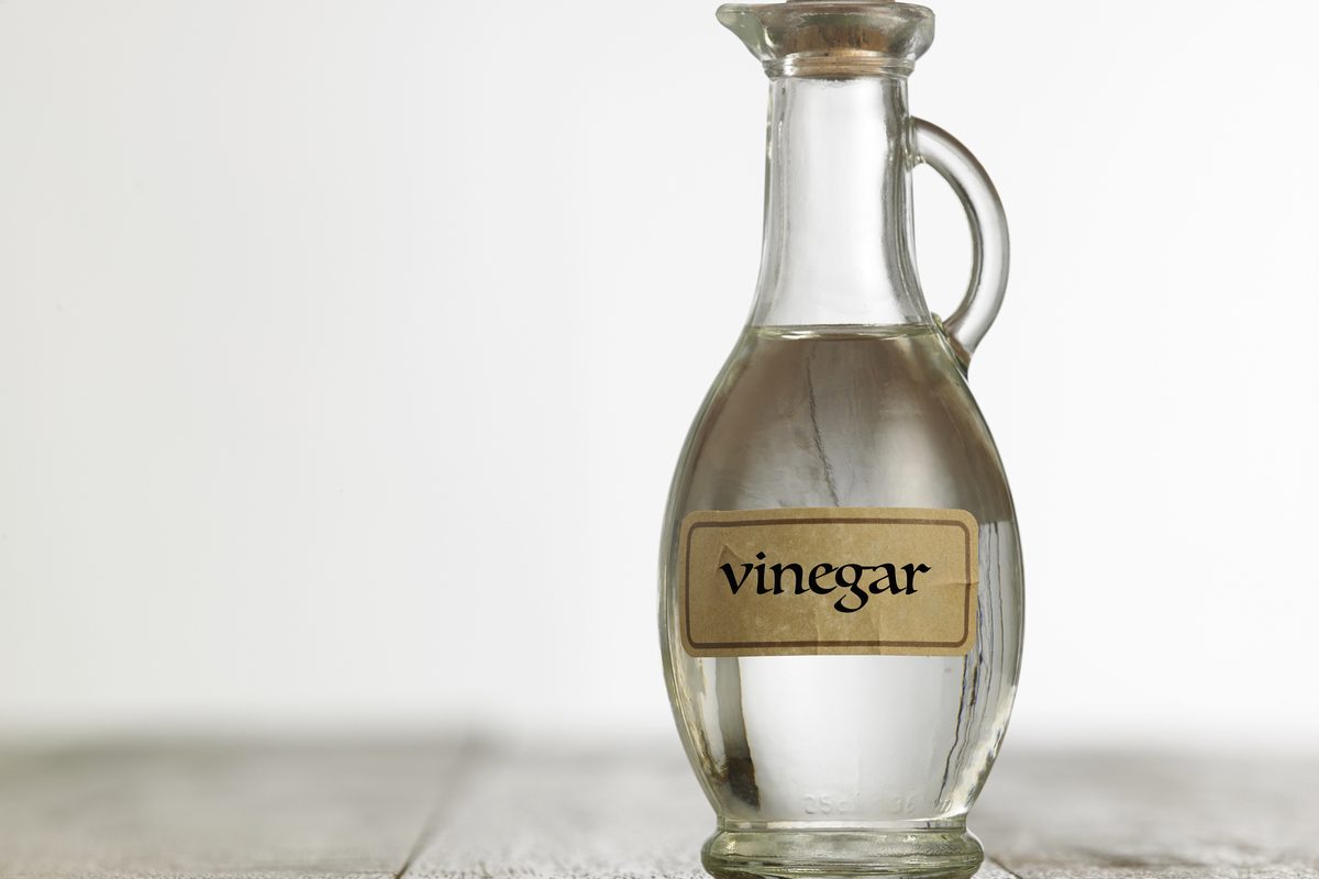 Glass bottle labeled as vinegar on table