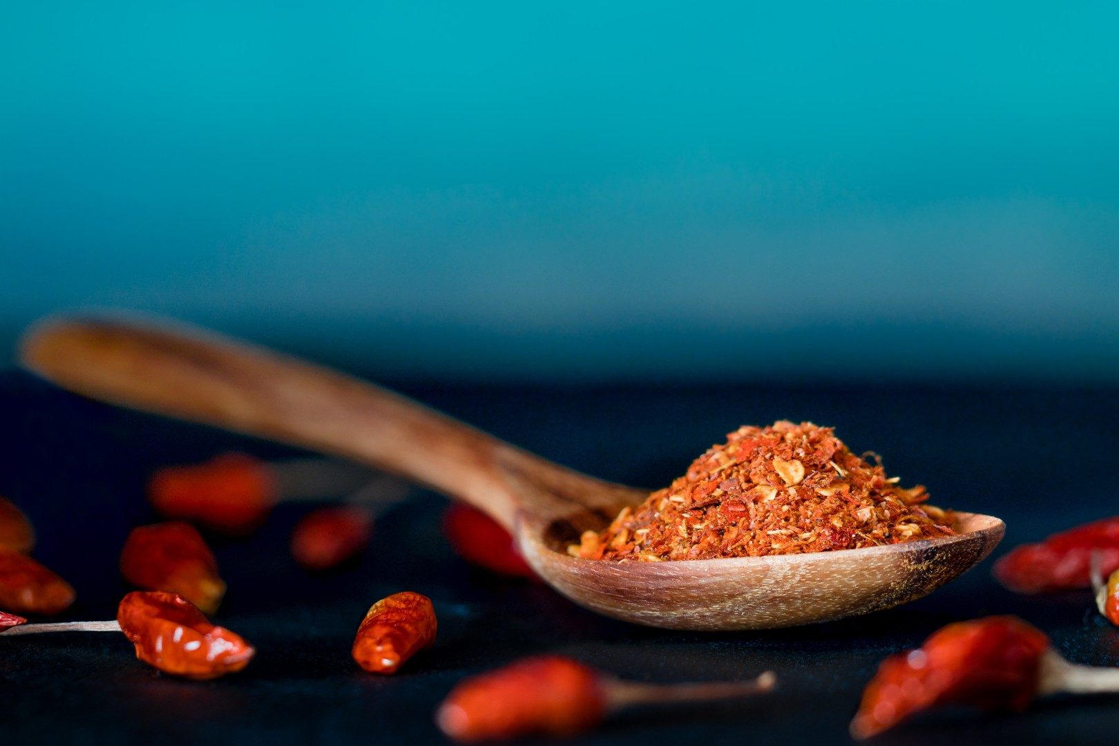 Spoon holding chili peppers lies on a table