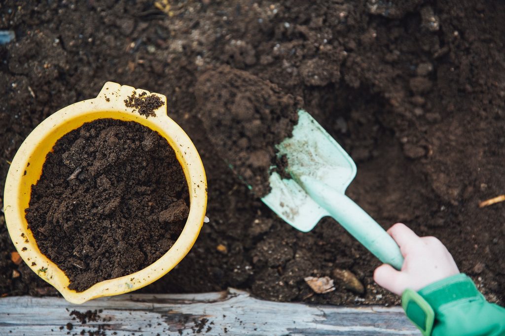 person digging in compost