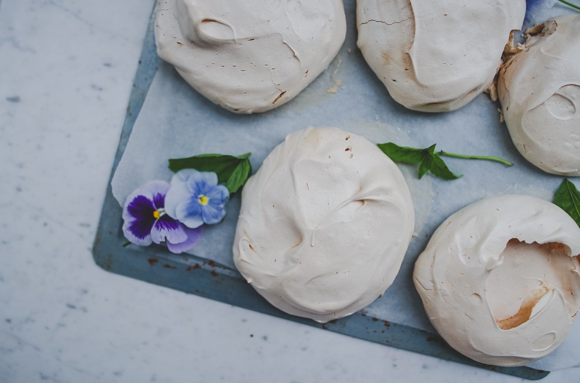 A tray of white cookies with violets