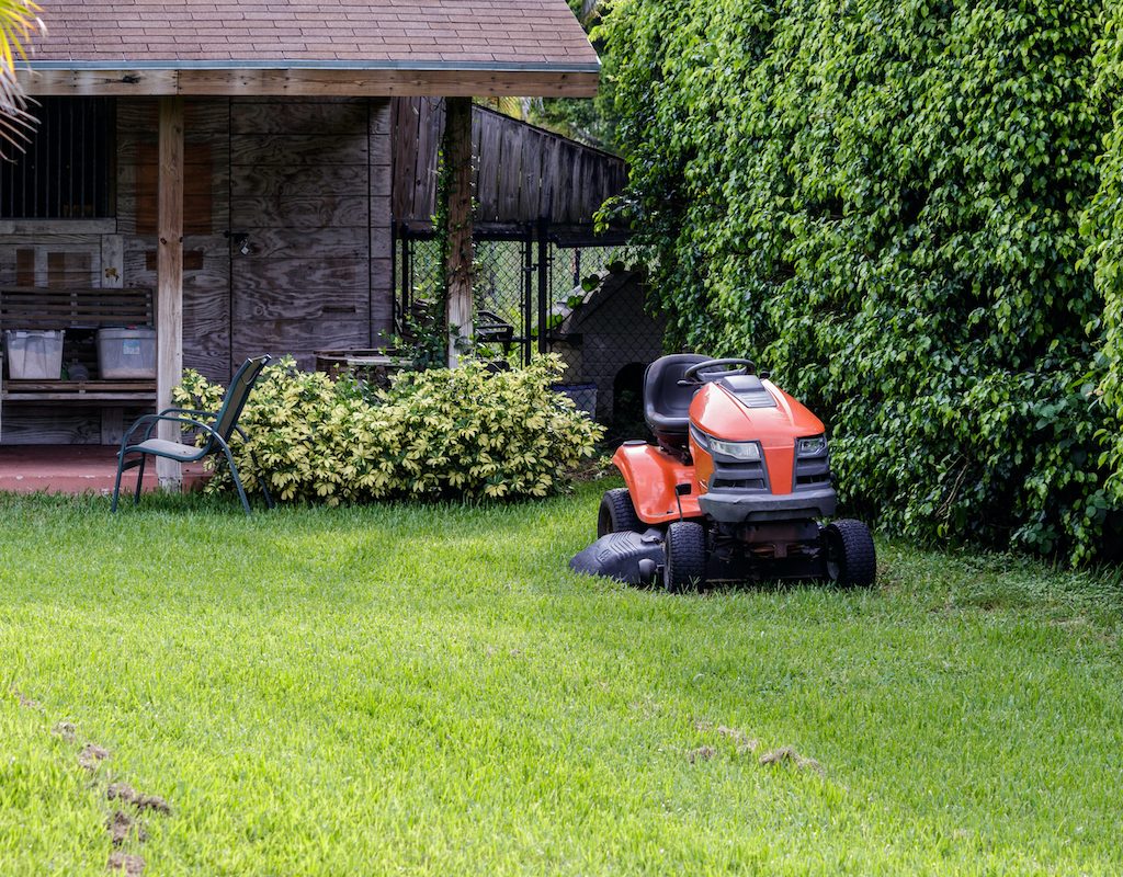 A red lawn mower in front of a house