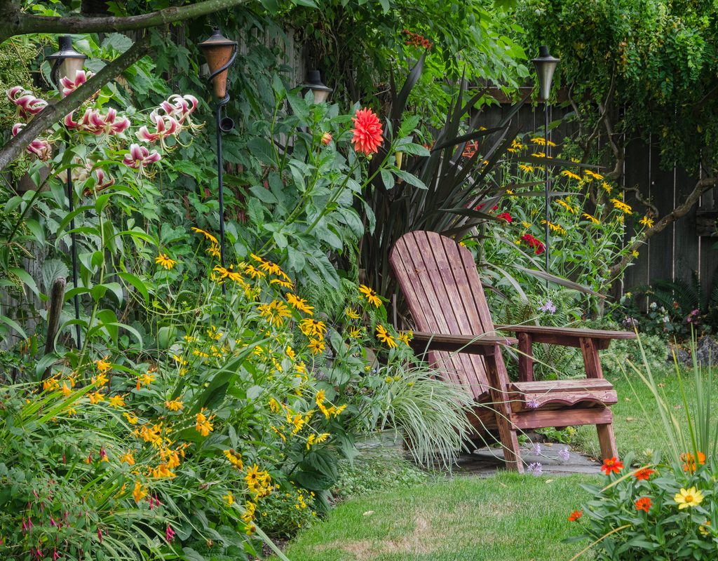 chair on lawn with perennial border