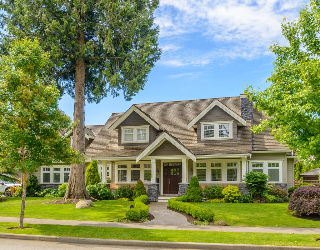 street view of a gray house with manicured landscape