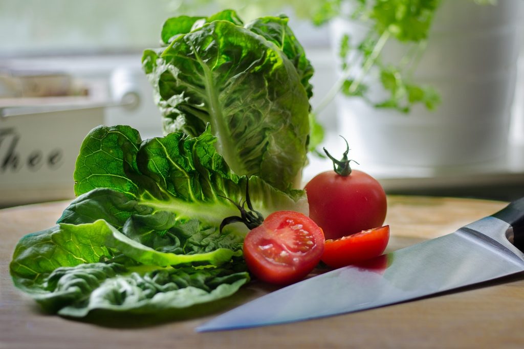 Lettuce and tomato with a kitchen knife