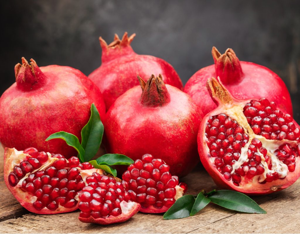 A group of pomegranates and pomegranate seeds