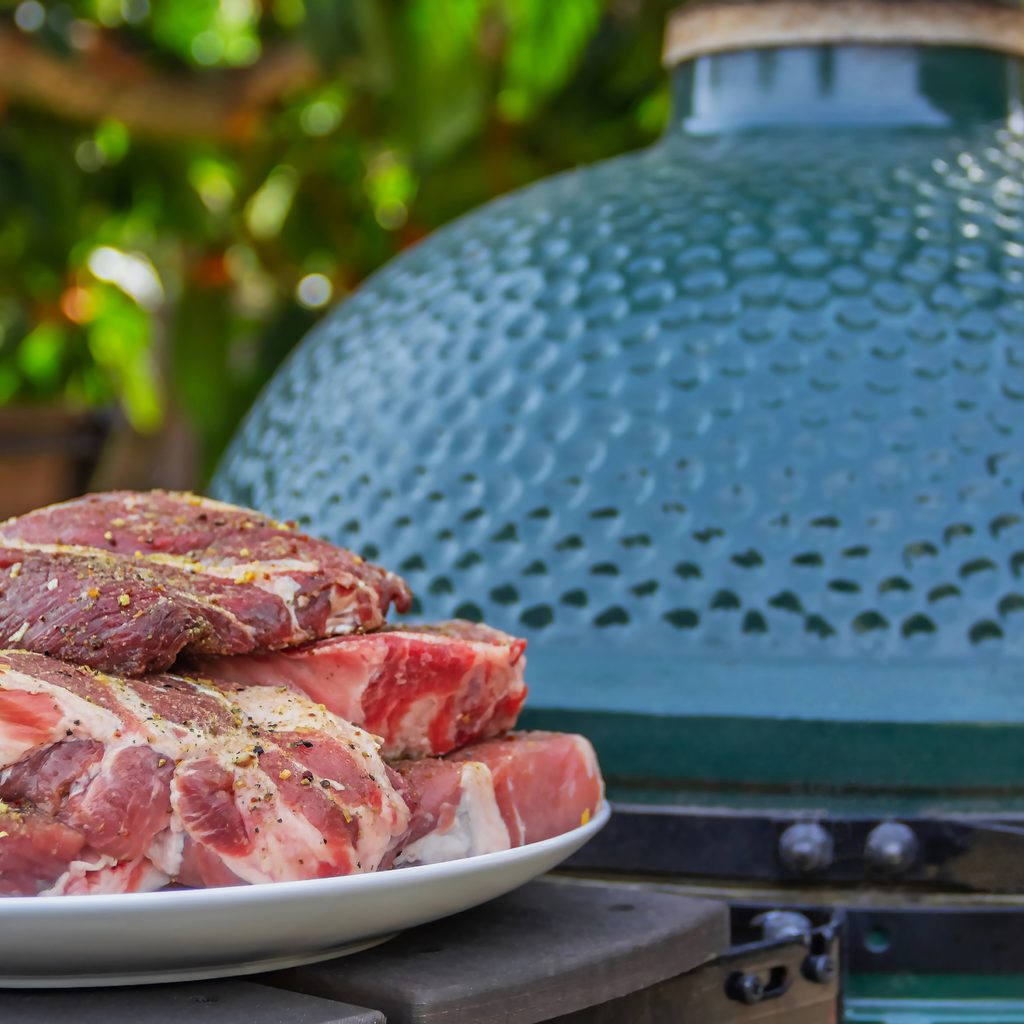 Raw Steaks Next To Kamado Grill