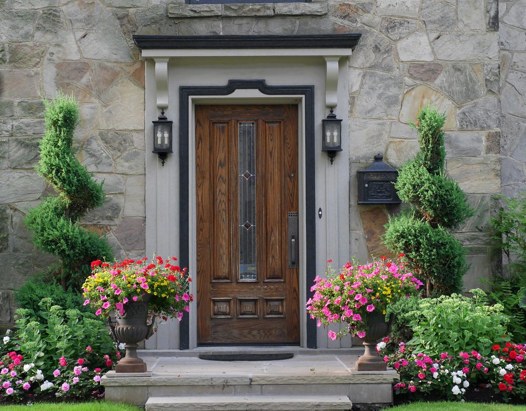 stone building with wood door and potted plants