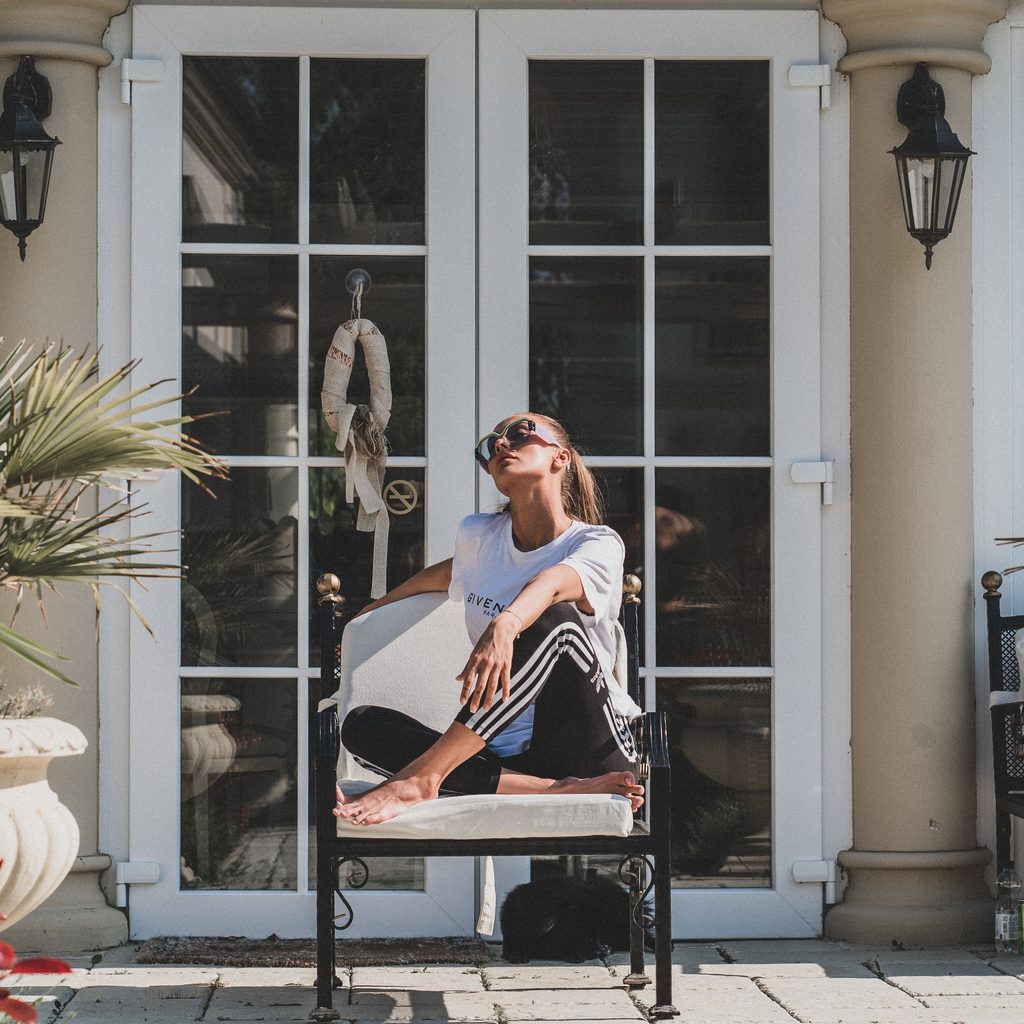 Woman Sitting on Chair Near House