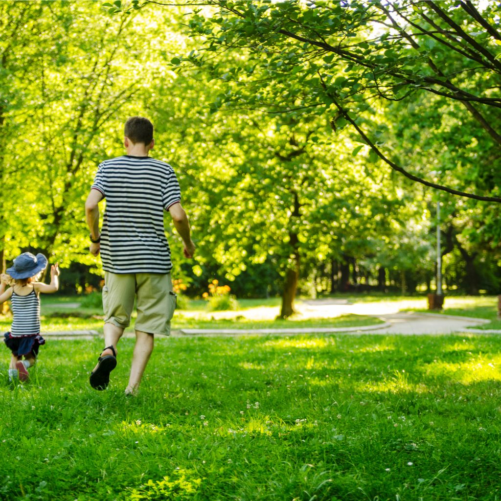 Parent and child walking in a green space