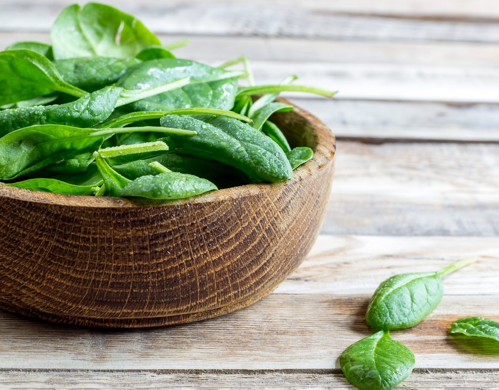 Freshly harvested spinach leaves in a bowl