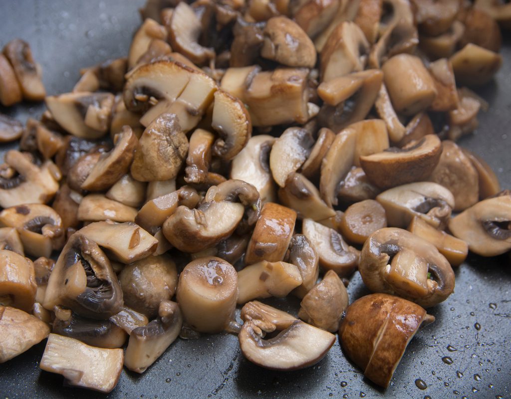 A pan full of sauteed cremini mushroom chunks