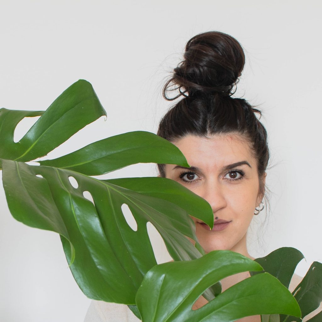 woman behind green plant