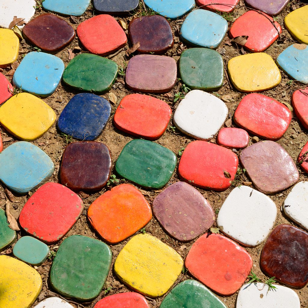 An assortment of colorful stone squares set against each other in the dirt