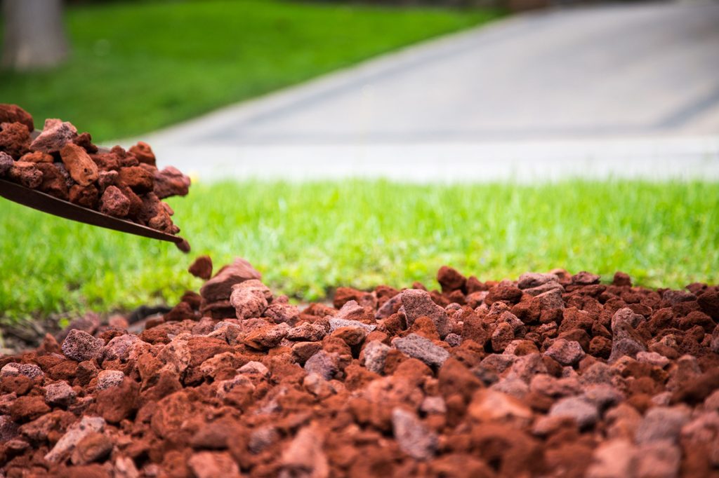 Shoveling red lava rocks
