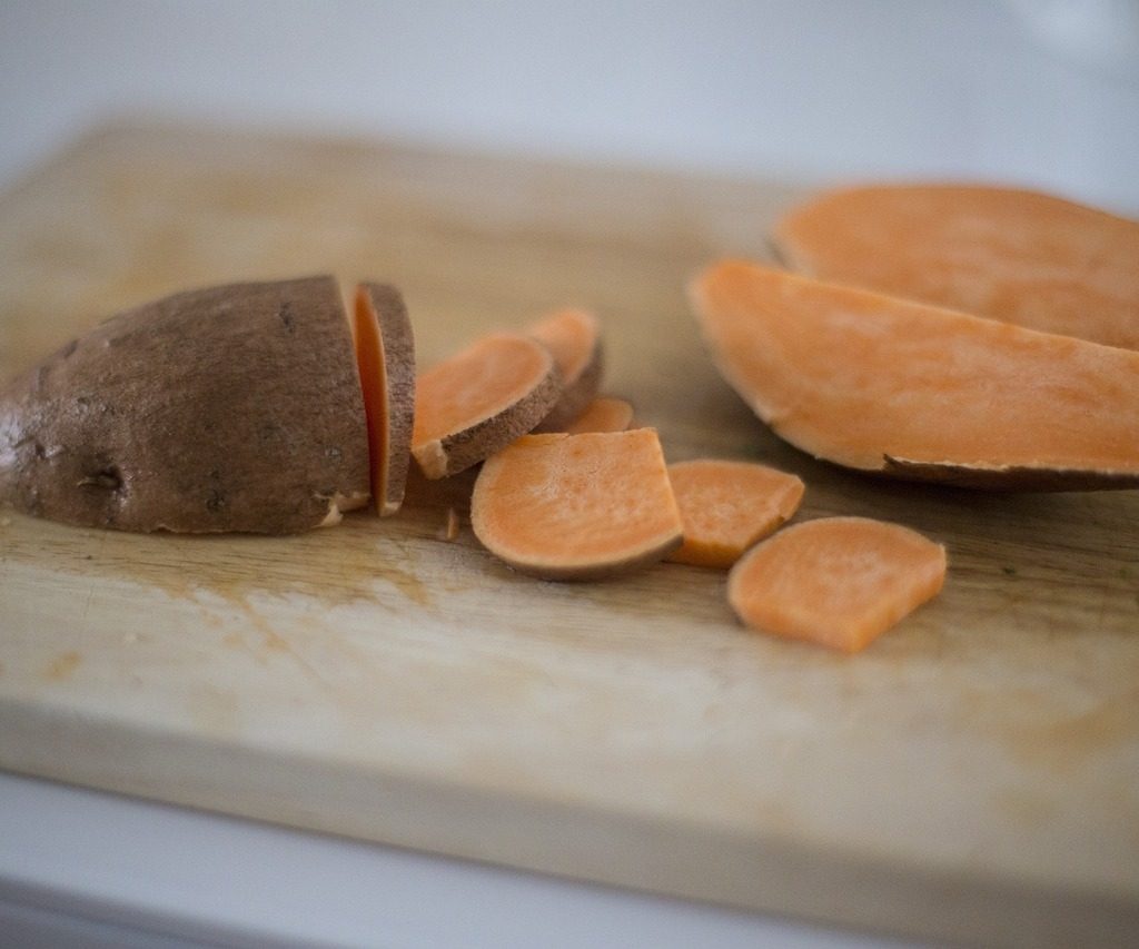 A sliced sweet potato on a cutting board