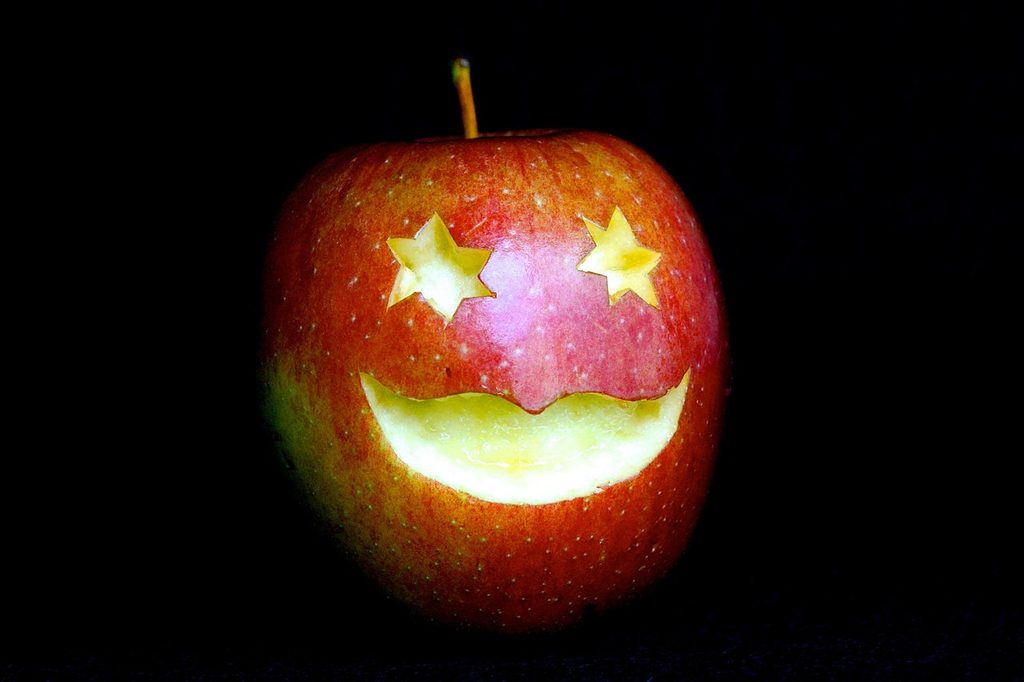A red apple with a face carved into it