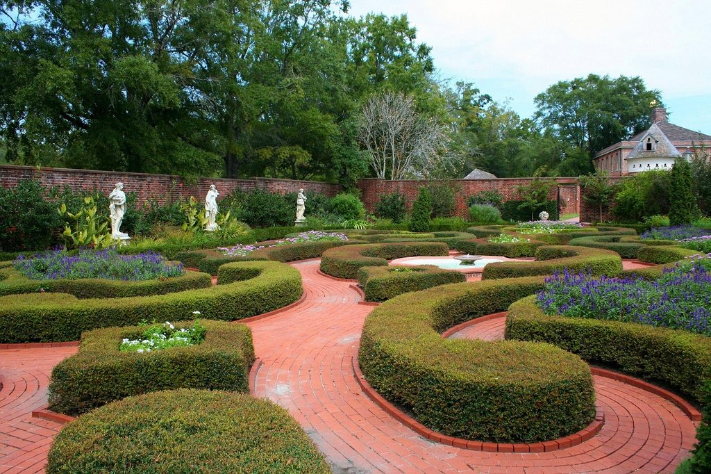 An English garden with small hedges and a brick pathway