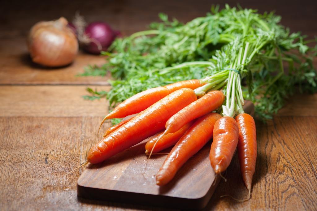 Clean carrots on a wooden cutting board