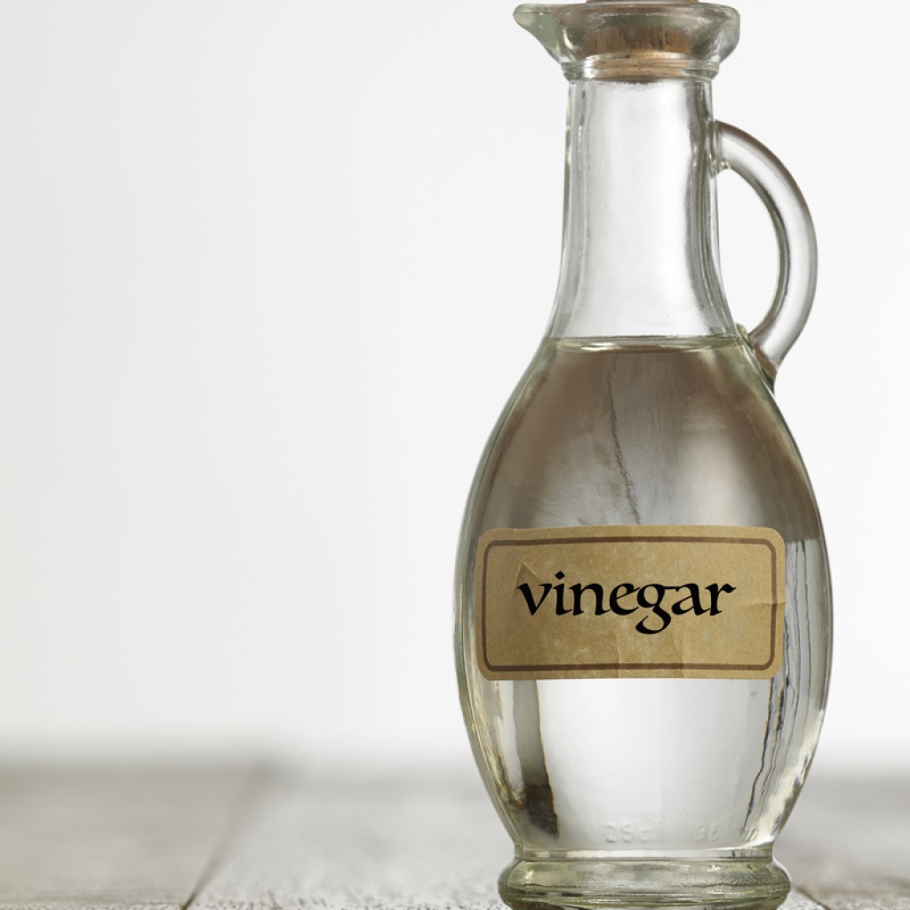Glass bottle labeled vinegar on table