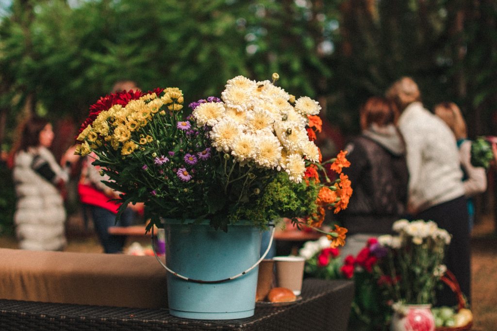colorful flowers arranged in blue bucket