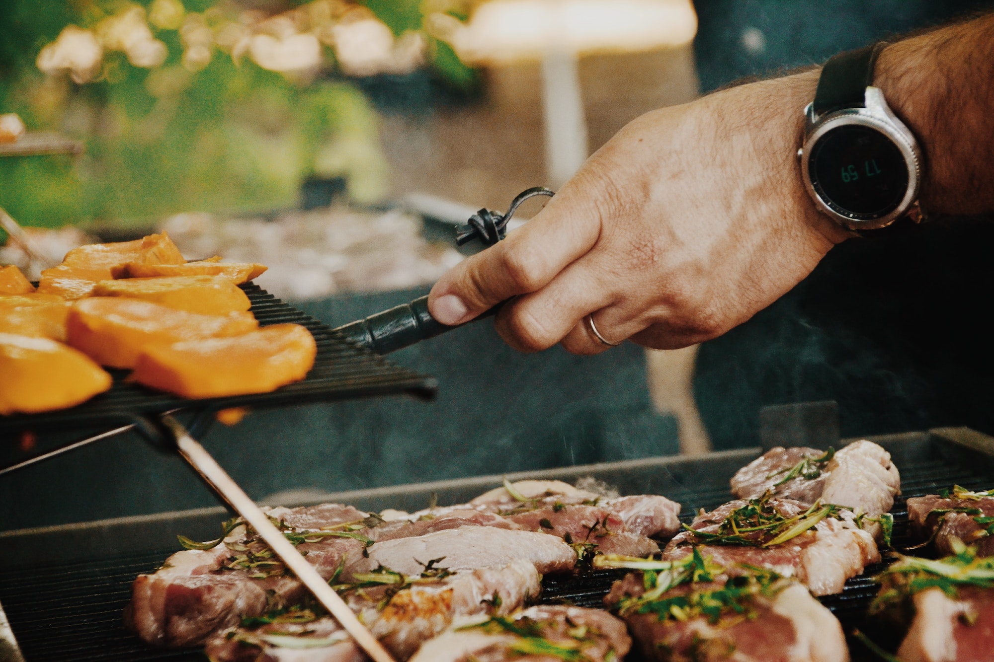 person grilling food on barbecue outside