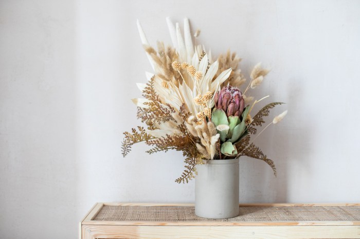 An arrangement of dried flowers in a light gray vase