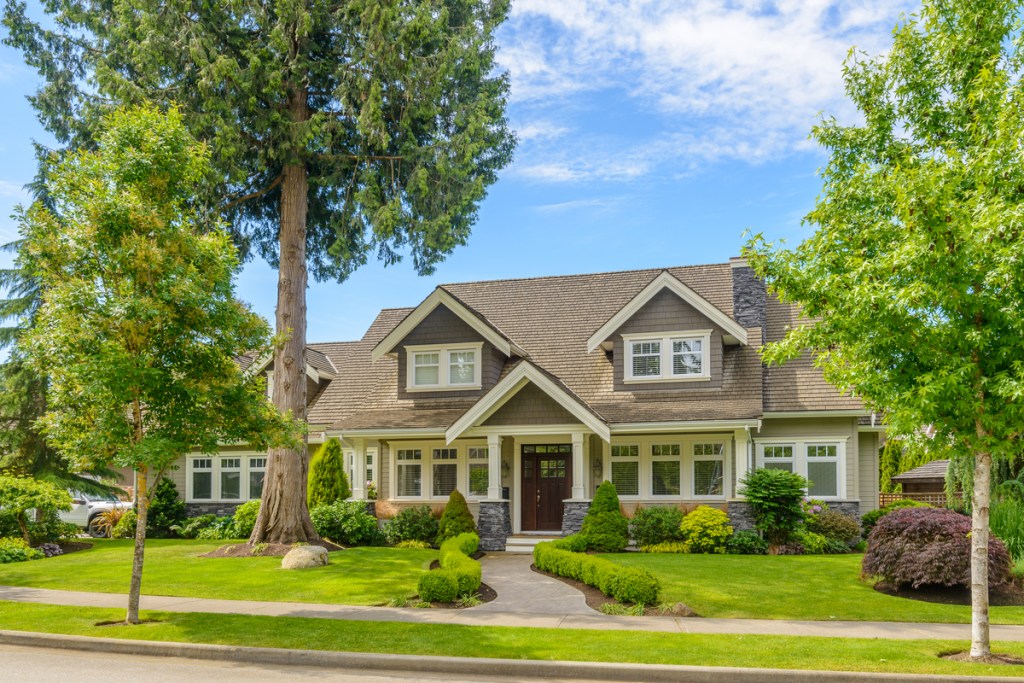 street view of a gray house with manicured landscape