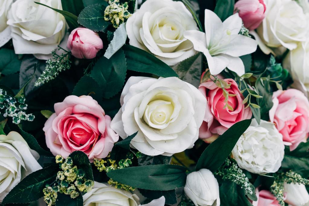 White and pink silk roses with dark green leaves