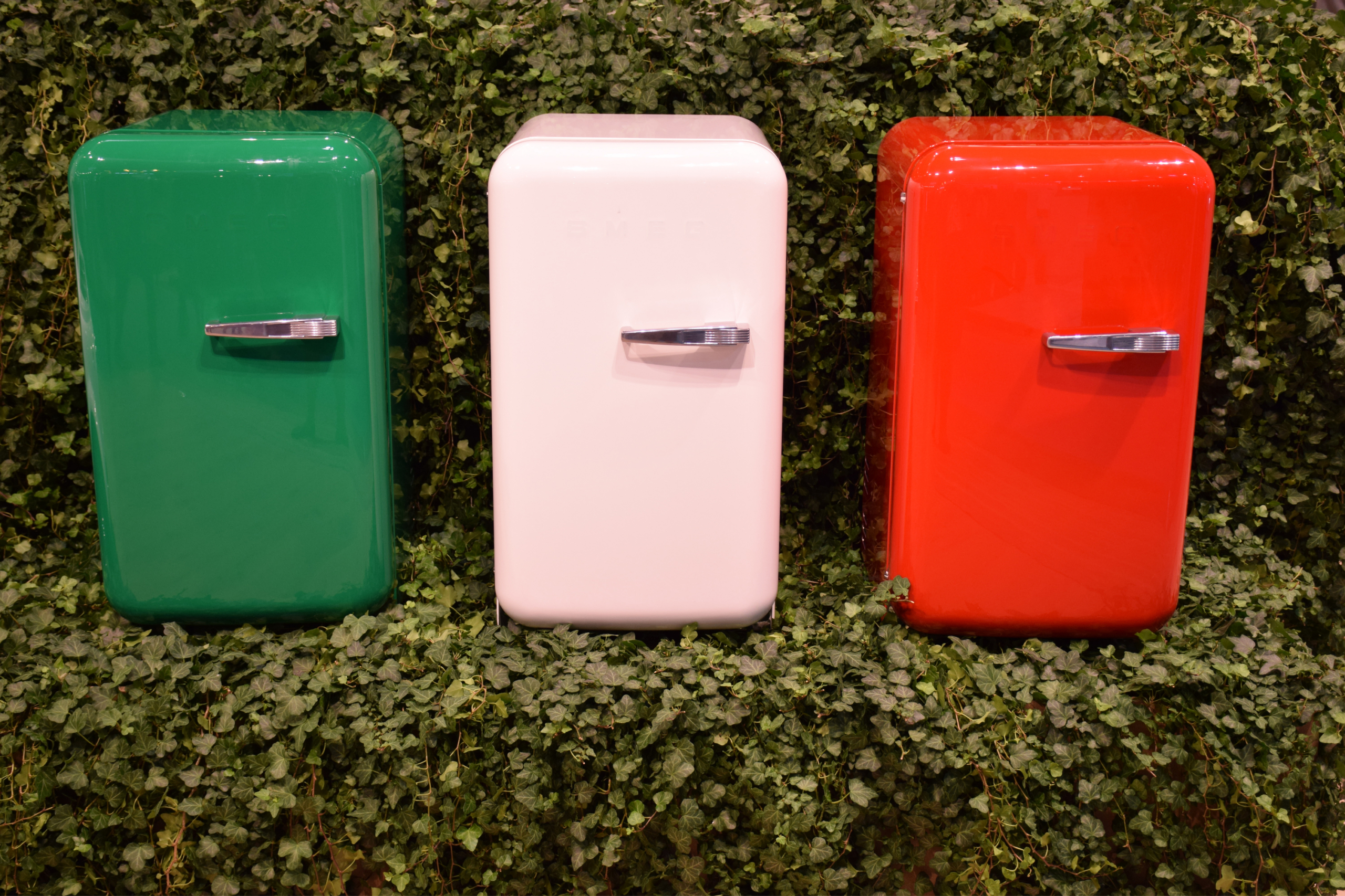 Three mini fridges on foliage