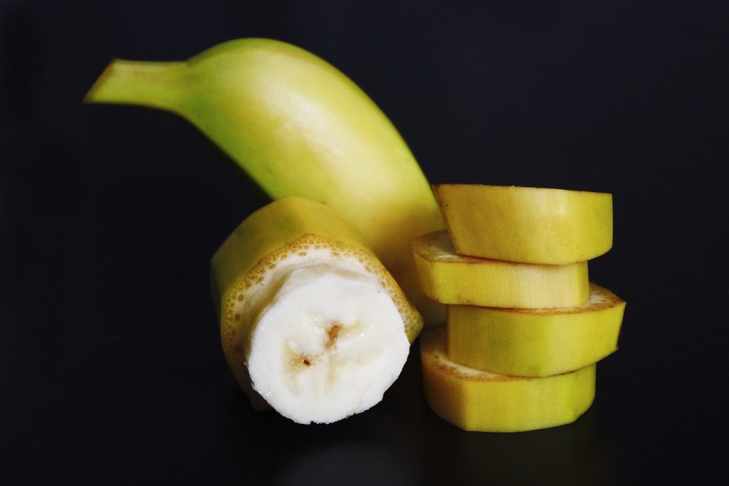 A banana with banana slices stacked next to it