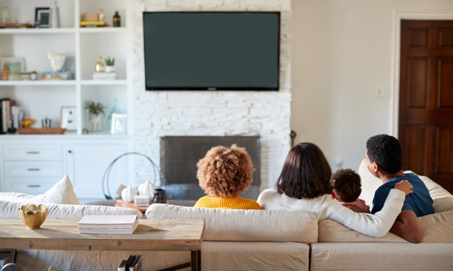 Family sitting on a couch watching TV