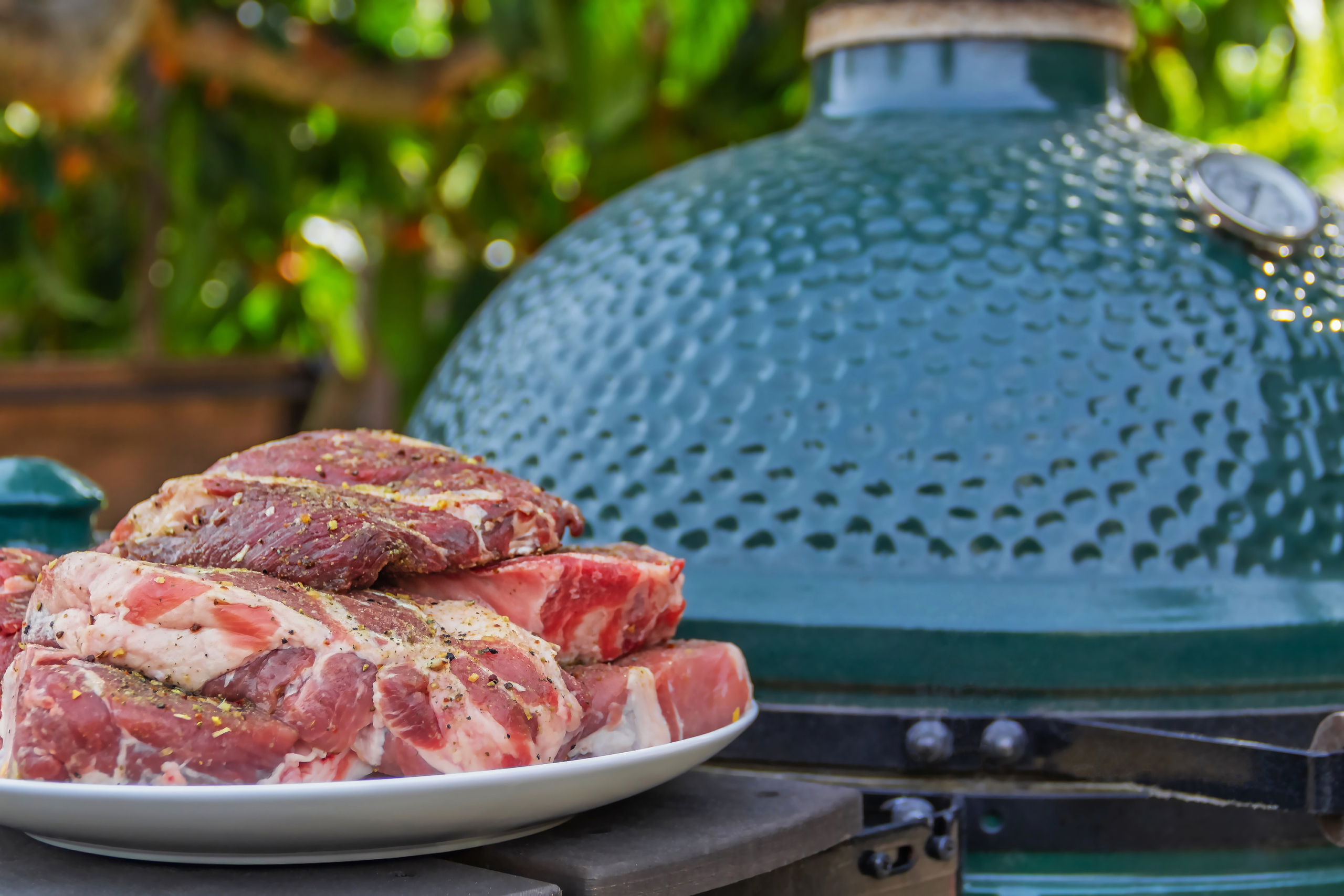 Raw Steaks Next To Kamado Grill