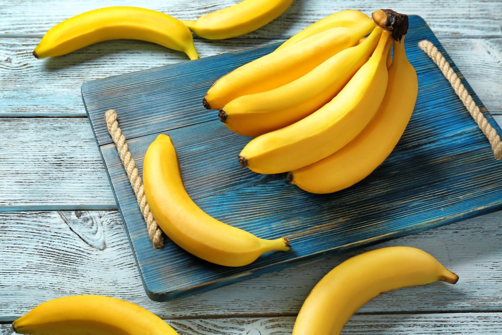 Bundle of bananas on a wooden cutting board