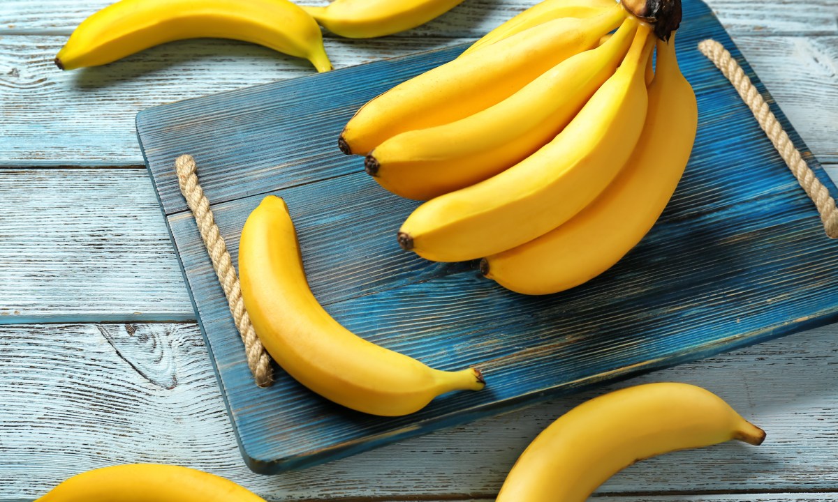 Bundle of bananas on a wooden cutting board