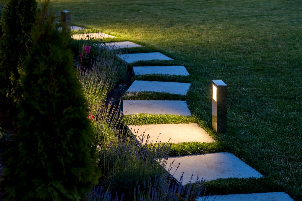 Outdoor lights beside a path of square stepping stones