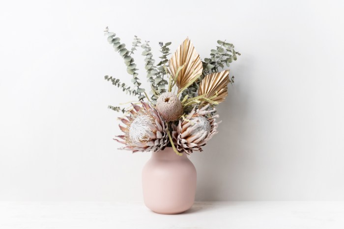 A dried floral arrangement in a pink vase