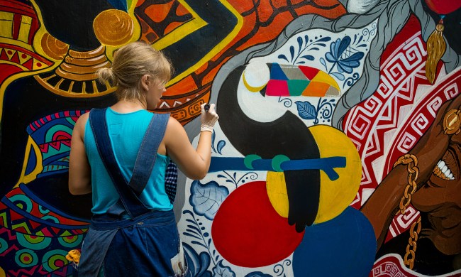 Woman painting on outdoor wall