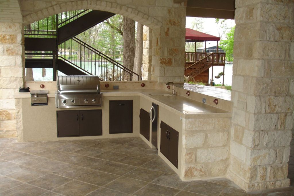 Outdoor kitchen with stone countertop and floor