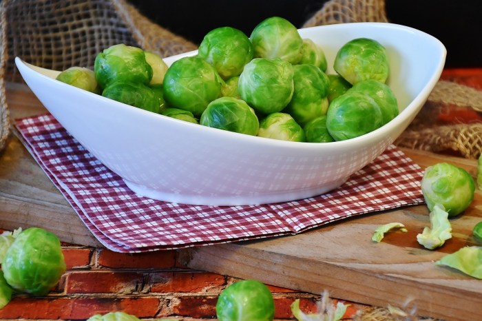 A gravy boat of Brussels sprouts on a cutting board