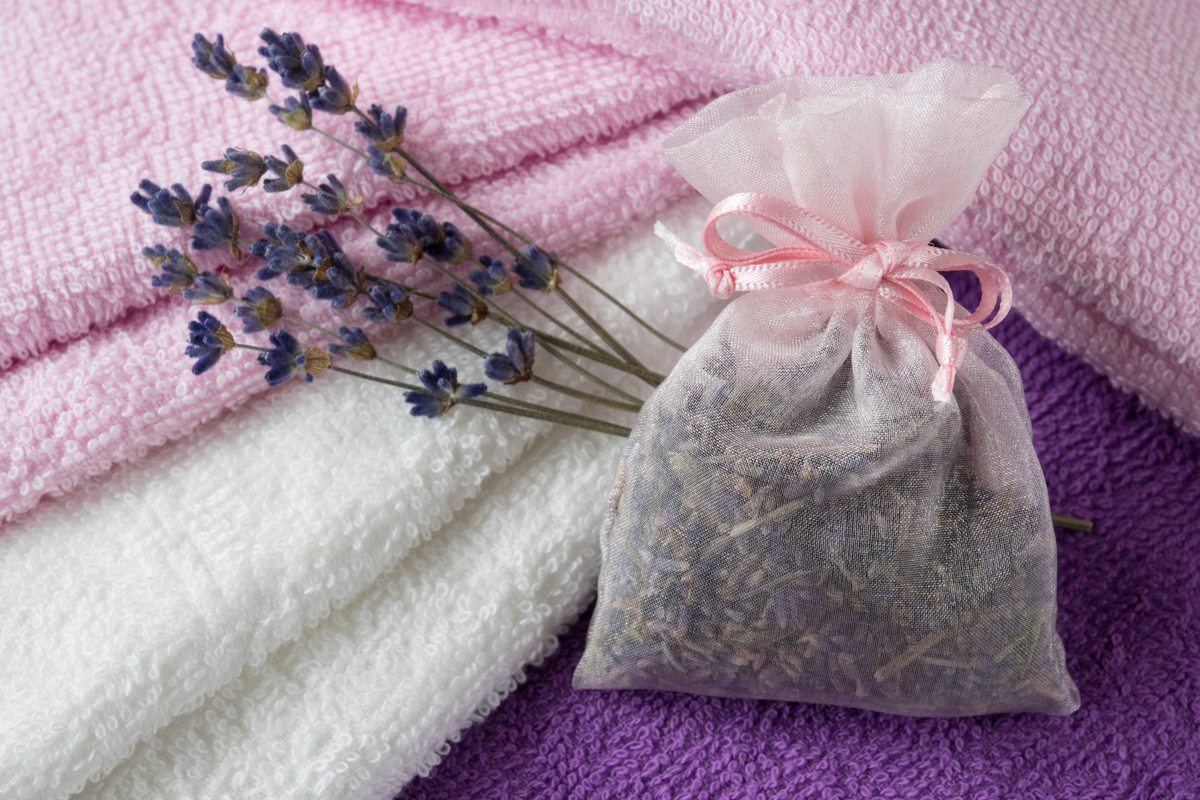 A small bag of dried lavender flowers leaning against freshly folded towels