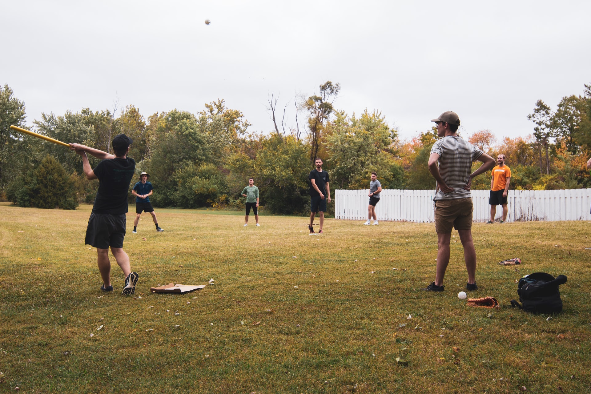 People standing in grass playing baseball