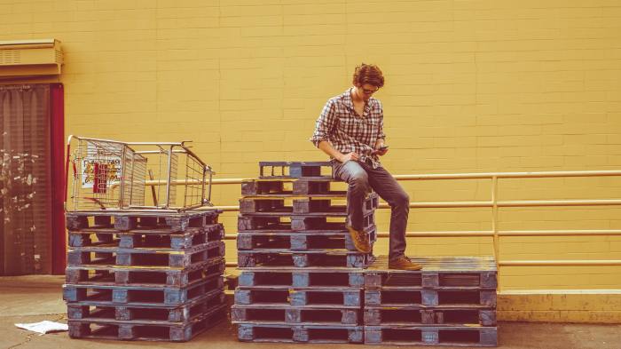 Person sitting on wooden pallets