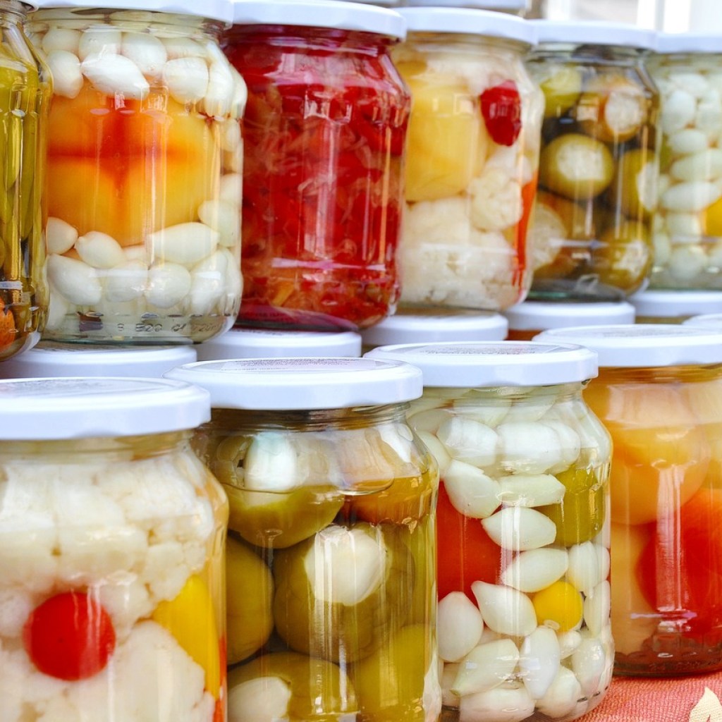 Rows of assorted vegetables pickling in glass jars