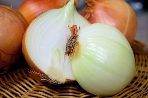 Onions in a whicker basket, one cut in half to show the onion's center