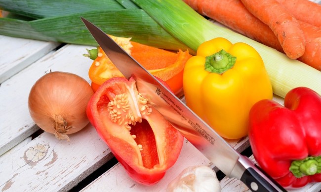 Fresh vegetables with a knife on a wooden surface