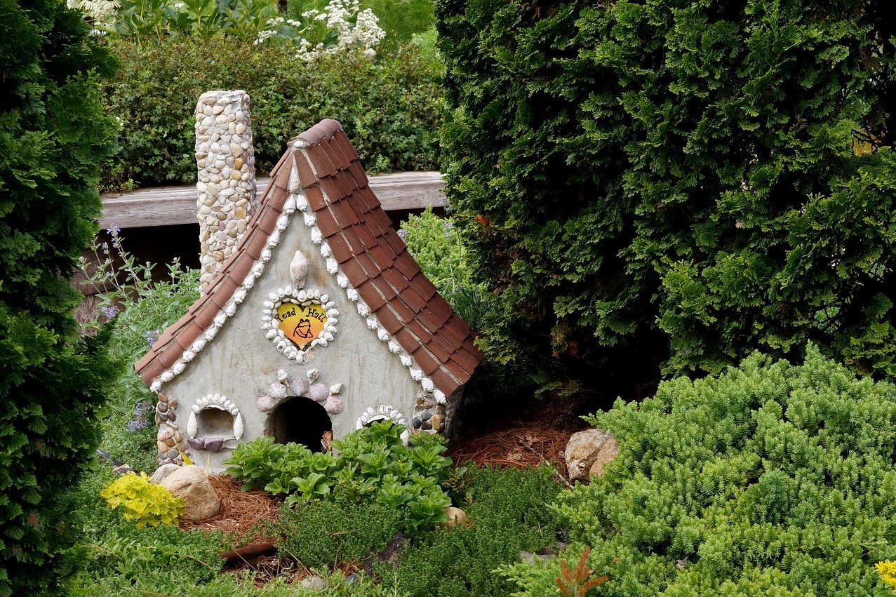 A white ceramic house decoration in a small garden