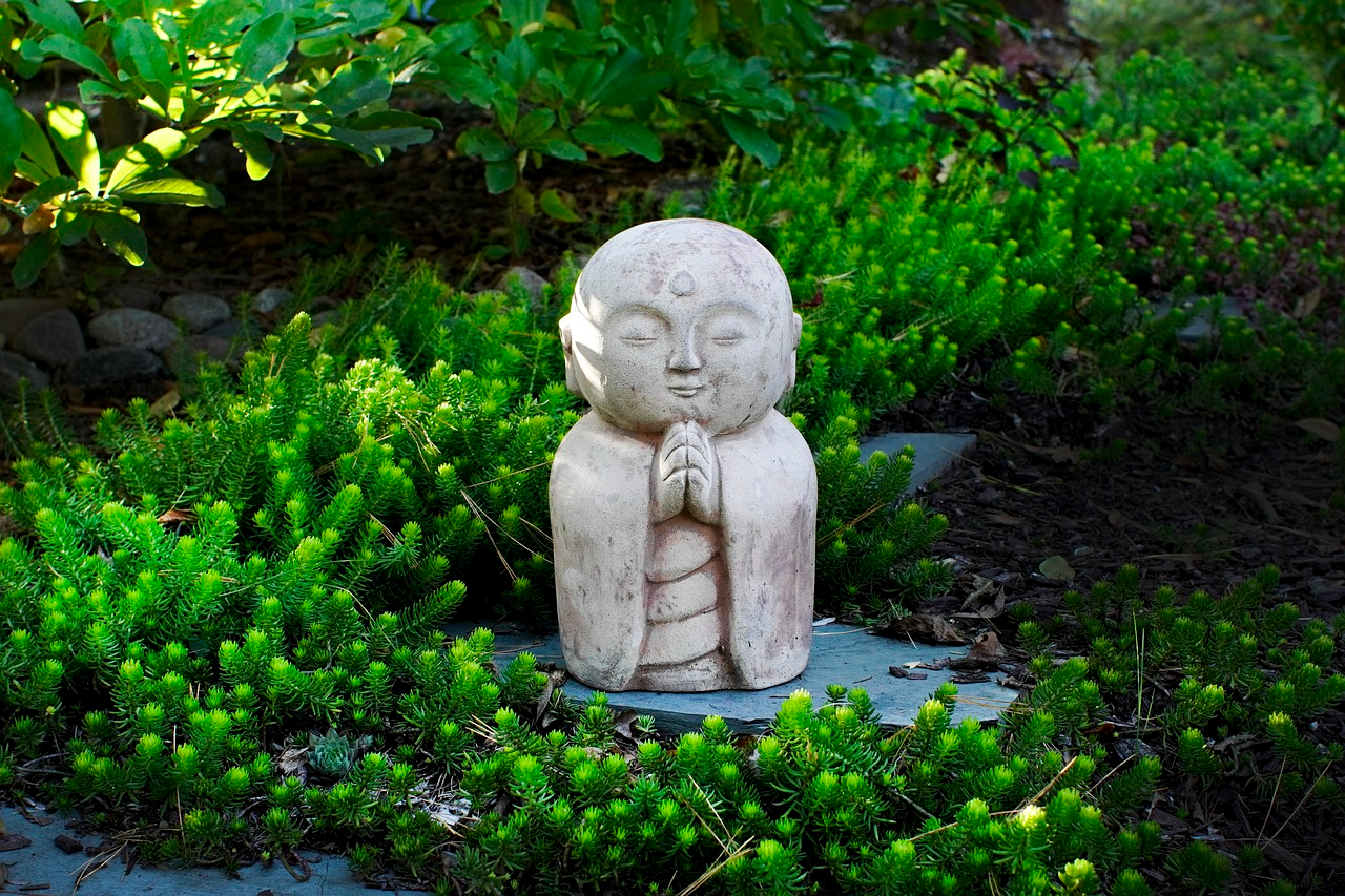 A small Buddha statue in a zen garden