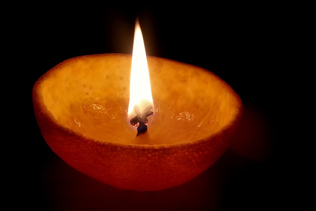 Half of an orange peel turned into an oil lamp